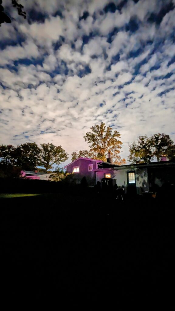 A house at night under a dramatic cloudy sky.