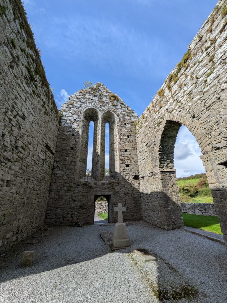 Interior of a roofless medieval stone abbey in Ireland, called Corcomroe Abbey.