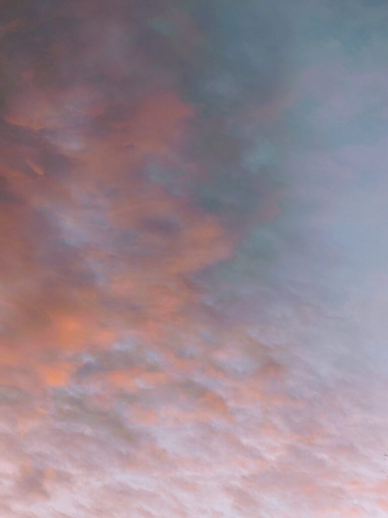 Soft, painterly clouds at sunset in pink and blue.